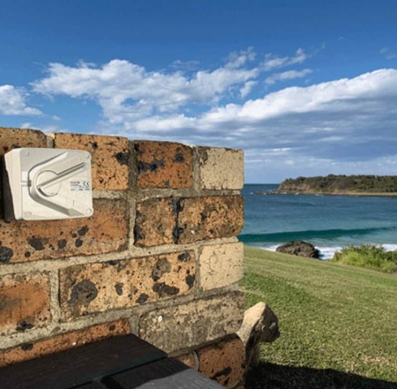Outdoor electrical power outlet on a brick wall on a coastal headland